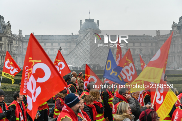 French General Confederation of Labour (CGT) unionists hold smoke canisters as they gather in front of Paris' Louvre Museum on December 20,...