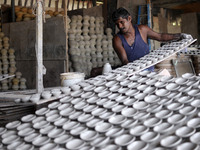 A pottery maker arranging a clay lantern or ‘diya’ in Kuala Selangor, Malaysia. Diyas are the small earthen lamps primarily used during Diwa...