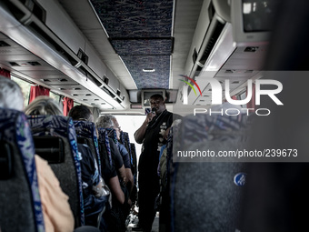 Don Gaetano, an italian priest, inside the bus on the road to Medjugorje talks with pilgrims and prays during the pilgrimage to Medjugorje....