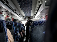 Don Gaetano, an italian priest, inside the bus on the road to Medjugorje talks with pilgrims and prays during the pilgrimage to Medjugorje....