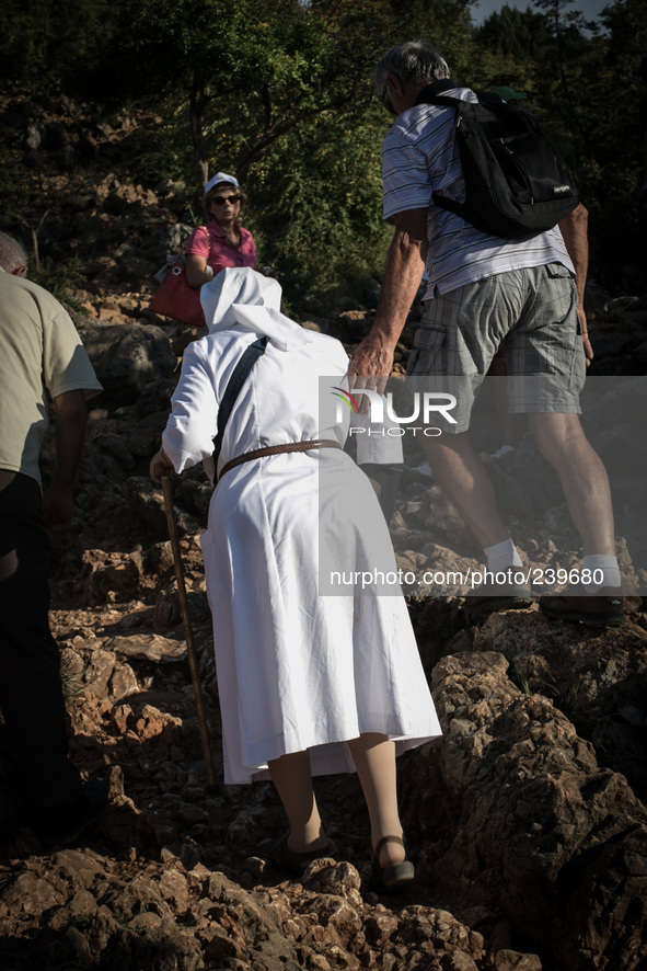 A nun on a steep path that leads on the very place of the apparitions of Our Lady,  called Podbrdo and Apparition Hill.Almost one million pe...