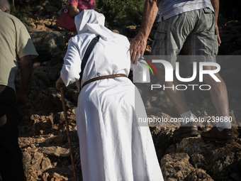 A nun on a steep path that leads on the very place of the apparitions of Our Lady,  called Podbrdo and Apparition Hill.Almost one million pe...