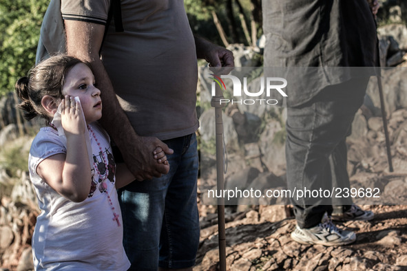 A girl with her father on a steep path that leads on the very place of the apparitions of Our Lady,  called Podbrdo and Apparition Hill.Almo...