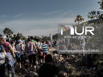 A statue of Virgin Mary on the the Apparition Hill, in Medjugorie. Pilgrims on a steep path that leads on the very place of the apparitions...