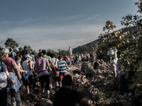 A statue of Virgin Mary on the the Apparition Hill, in Medjugorie. Pilgrims on a steep path that leads on the very place of the apparitions...