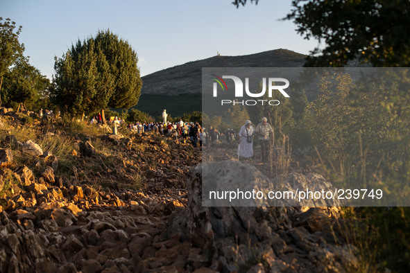 A man help a nun on a steep path that leads on the very place of the apparitions of Our Lady,  called Podbrdo and Apparition Hill.Almost one...