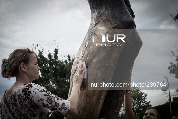 Girl takes a drop from the knee of the bronze sculpture of the Risen Christ. Mysterious liquid has been gathered by Medjugorje pilgrims sinc...