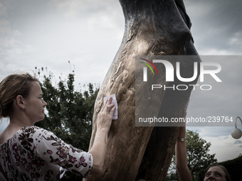 Girl takes a drop from the knee of the bronze sculpture of the Risen Christ. Mysterious liquid has been gathered by Medjugorje pilgrims sinc...