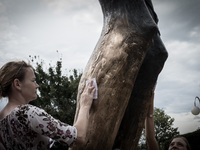 Girl takes a drop from the knee of the bronze sculpture of the Risen Christ. Mysterious liquid has been gathered by Medjugorje pilgrims sinc...