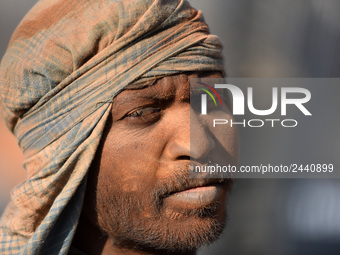 A layer of dust seen on Portrait on Indian labourers as after stacks bricks by balancing them onto his head at a brick factory in Lalitpur,...