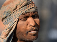 A layer of dust seen on Portrait on Indian labourers as after stacks bricks by balancing them onto his head at a brick factory in Lalitpur,...