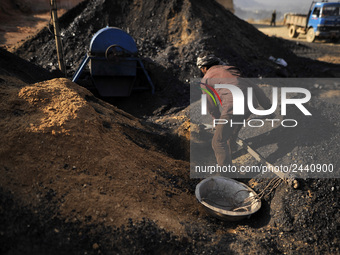 A Migrant worker from India, arrange coal to carry at a brick factory in Lalitpur, Nepal on Tuesday, January 23, 2018. (