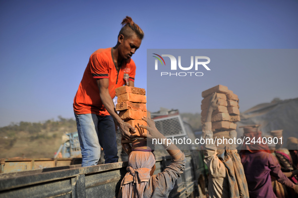 Migrant Indian labourers stacks bricks by balancing them onto his head at a brick factory in Lalitpur, Nepal on Tuesday, January 23, 2018. I...