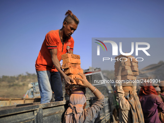 Migrant Indian labourers stacks bricks by balancing them onto his head at a brick factory in Lalitpur, Nepal on Tuesday, January 23, 2018. I...