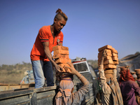 Migrant Indian labourers stacks bricks by balancing them onto his head at a brick factory in Lalitpur, Nepal on Tuesday, January 23, 2018. I...