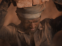 A Migrant Indian labourer stacks bricks by balancing them onto his head at a brick factory in Lalitpur, Nepal on Tuesday, January 23, 2018....