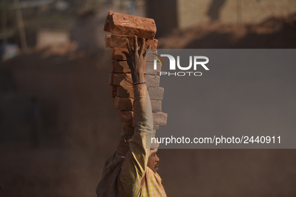 A Migrant Indian labourer stacks bricks by balancing them onto his head at a brick factory in Lalitpur, Nepal on Tuesday, January 23, 2018....