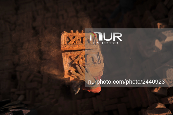 A Migrant Indian labourer stacks bricks by balancing them onto his head at a brick factory in Lalitpur, Nepal on Tuesday, January 23, 2018....