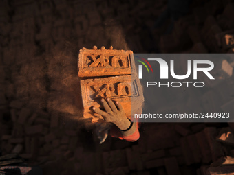 A Migrant Indian labourer stacks bricks by balancing them onto his head at a brick factory in Lalitpur, Nepal on Tuesday, January 23, 2018....