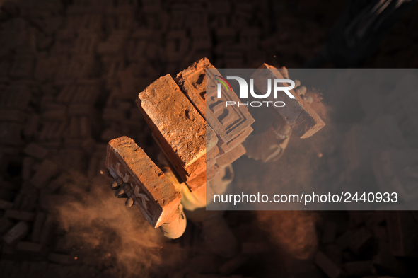 A Migrant Indian labourer stacks bricks by balancing them onto his head at a brick factory in Lalitpur, Nepal on Tuesday, January 23, 2018....