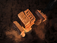 A Migrant Indian labourer stacks bricks by balancing them onto his head at a brick factory in Lalitpur, Nepal on Tuesday, January 23, 2018....