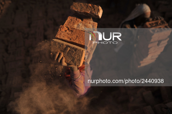 A Migrant Indian labourer stacks bricks by balancing them onto his head at a brick factory in Lalitpur, Nepal on Tuesday, January 23, 2018....