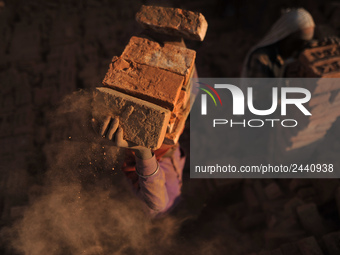 A Migrant Indian labourer stacks bricks by balancing them onto his head at a brick factory in Lalitpur, Nepal on Tuesday, January 23, 2018....