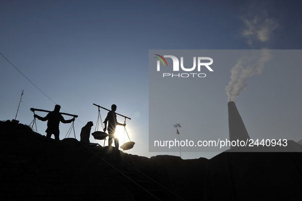 Migrant workers from India, carries mixed soil on a brick factory in Lalitpur, Nepal on Tuesday, January 23, 2018. 