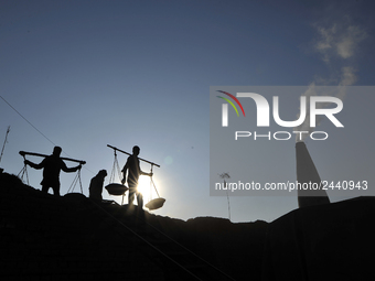 Migrant workers from India, carries mixed soil on a brick factory in Lalitpur, Nepal on Tuesday, January 23, 2018. (