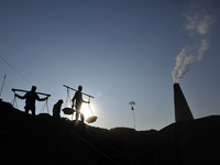 Migrant workers from India, carries mixed soil on a brick factory in Lalitpur, Nepal on Tuesday, January 23, 2018. (