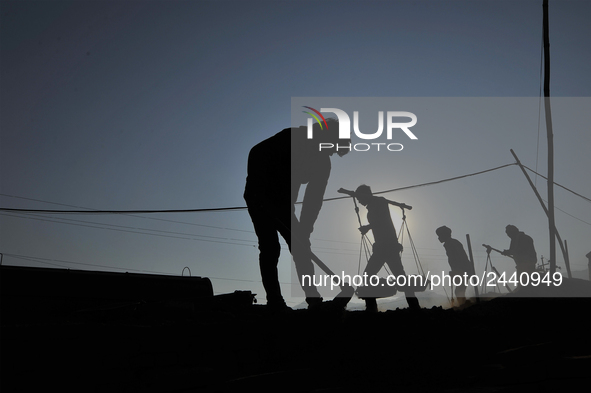 Migrant workers from India, carries mixed soil on a brick factory in Lalitpur, Nepal on Tuesday, January 23, 2018. 