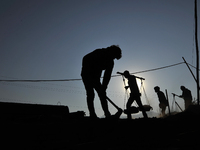 Migrant workers from India, carries mixed soil on a brick factory in Lalitpur, Nepal on Tuesday, January 23, 2018. (