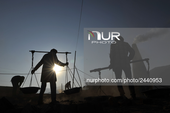 Migrant workers from India, carries mixed soil on a brick factory in Lalitpur, Nepal on Tuesday, January 23, 2018. 