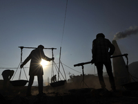 Migrant workers from India, carries mixed soil on a brick factory in Lalitpur, Nepal on Tuesday, January 23, 2018. (