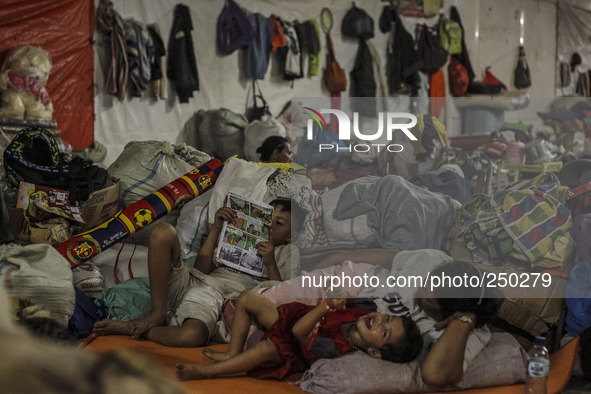 A woman and Shes children sleep in a refugee camp at Kabanjahe, North Sumatra, Indonesia, on Sept. 11, 2014. The volcano Mount Sinabung has...