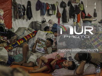 A woman and Shes children sleep in a refugee camp at Kabanjahe, North Sumatra, Indonesia, on Sept. 11, 2014. The volcano Mount Sinabung has...