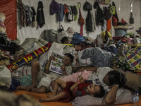 A woman and Shes children sleep in a refugee camp at Kabanjahe, North Sumatra, Indonesia, on Sept. 11, 2014. The volcano Mount Sinabung has...