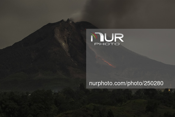 The slow shutter speed photo taken on Sept. 12, 2014 shows lava flowing out of Mount Sinabung as seen from Tiga Pancur village, North Sumatr...