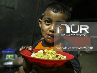 A children eat in a refugee camp at Kabanjahe, North Sumatra, Indonesia, on Sept. 11, 2014. The volcano Mount Sinabung has erupted intermitt...