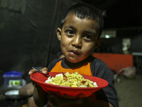 A children eat in a refugee camp at Kabanjahe, North Sumatra, Indonesia, on Sept. 11, 2014. The volcano Mount Sinabung has erupted intermitt...