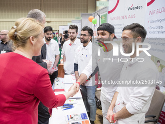 Mayor of Neukoelln Franzisk Giffey (L) visits the stand of Vivantes group during a Job Fair for Refugees and Migrants in Berlin, Germany on...