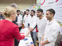 Mayor of Neukoelln Franzisk Giffey (L) visits the stand of Vivantes group during a Job Fair for Refugees and Migrants in Berlin, Germany on...