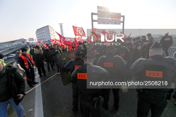 Striking Air France employees walk with union flags, followed by a groupf of French CRS anti-riot police, outside Charles de Gaulle airport...