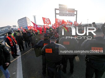 Striking Air France employees walk with union flags, followed by a groupf of French CRS anti-riot police, outside Charles de Gaulle airport...