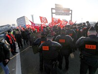 Striking Air France employees walk with union flags, followed by a groupf of French CRS anti-riot police, outside Charles de Gaulle airport...