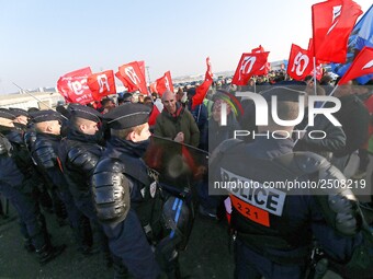 Striking Air France employees walk with union flags, followed by a groupf of French CRS anti-riot police, outside Charles de Gaulle airport...