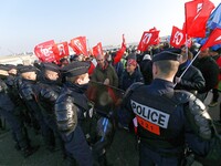 Striking Air France employees walk with union flags, followed by a groupf of French CRS anti-riot police, outside Charles de Gaulle airport...