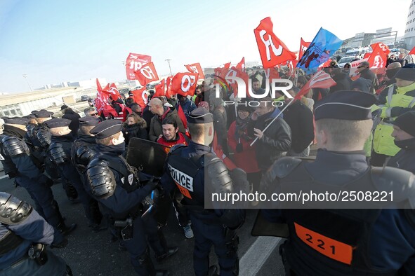 Striking Air France employees walk with union flags, followed by a groupf of French CRS anti-riot police, outside Charles de Gaulle airport...