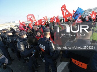 Striking Air France employees walk with union flags, followed by a groupf of French CRS anti-riot police, outside Charles de Gaulle airport...