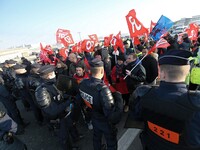 Striking Air France employees walk with union flags, followed by a groupf of French CRS anti-riot police, outside Charles de Gaulle airport...